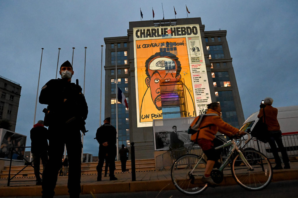 Карикатура на французскую сатирическую еженедельную газету Charlie Hebdo проецируются на фасад Hotel de Region во Франции