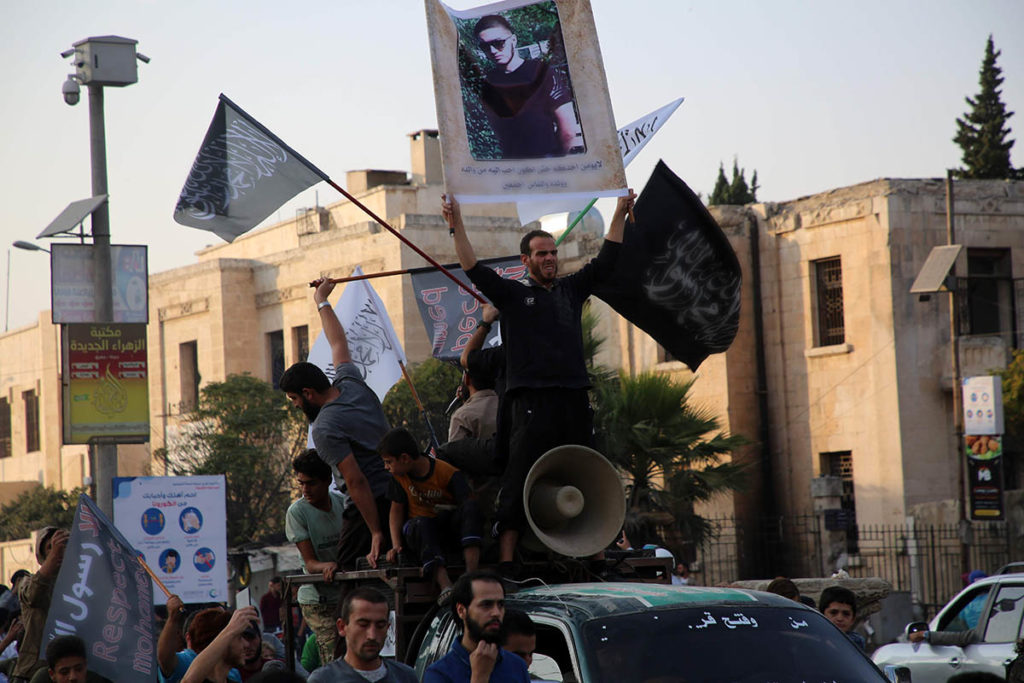 Сирийские демонстранты подняли исламистские флаги и портрет Абдуллаха Анзорова в его поддержку.